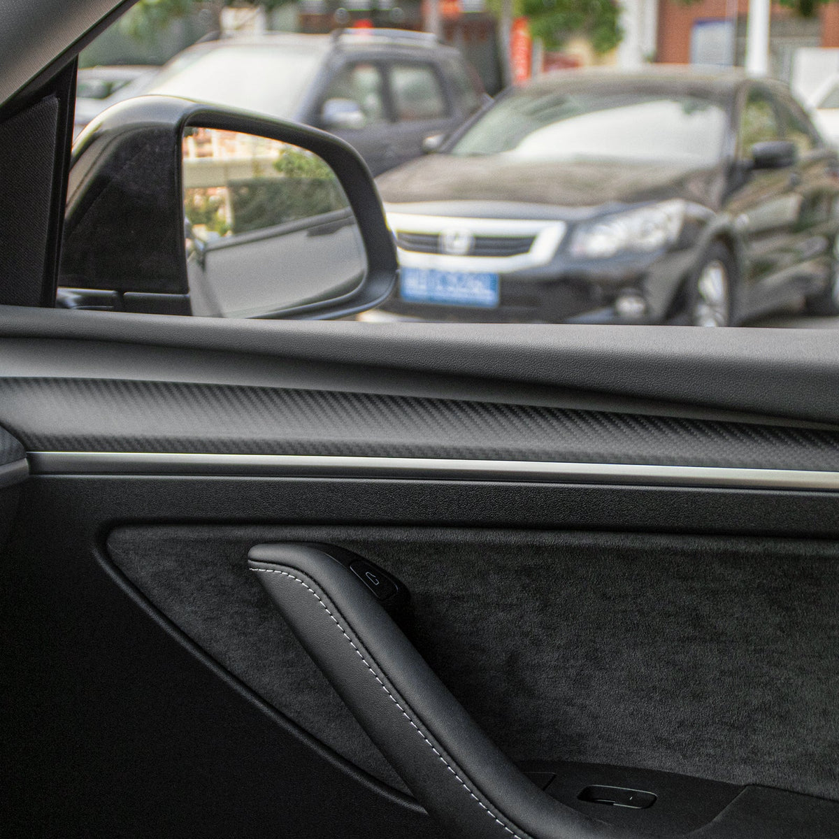 Carbon fiber door panel trim fitted inside a Tesla