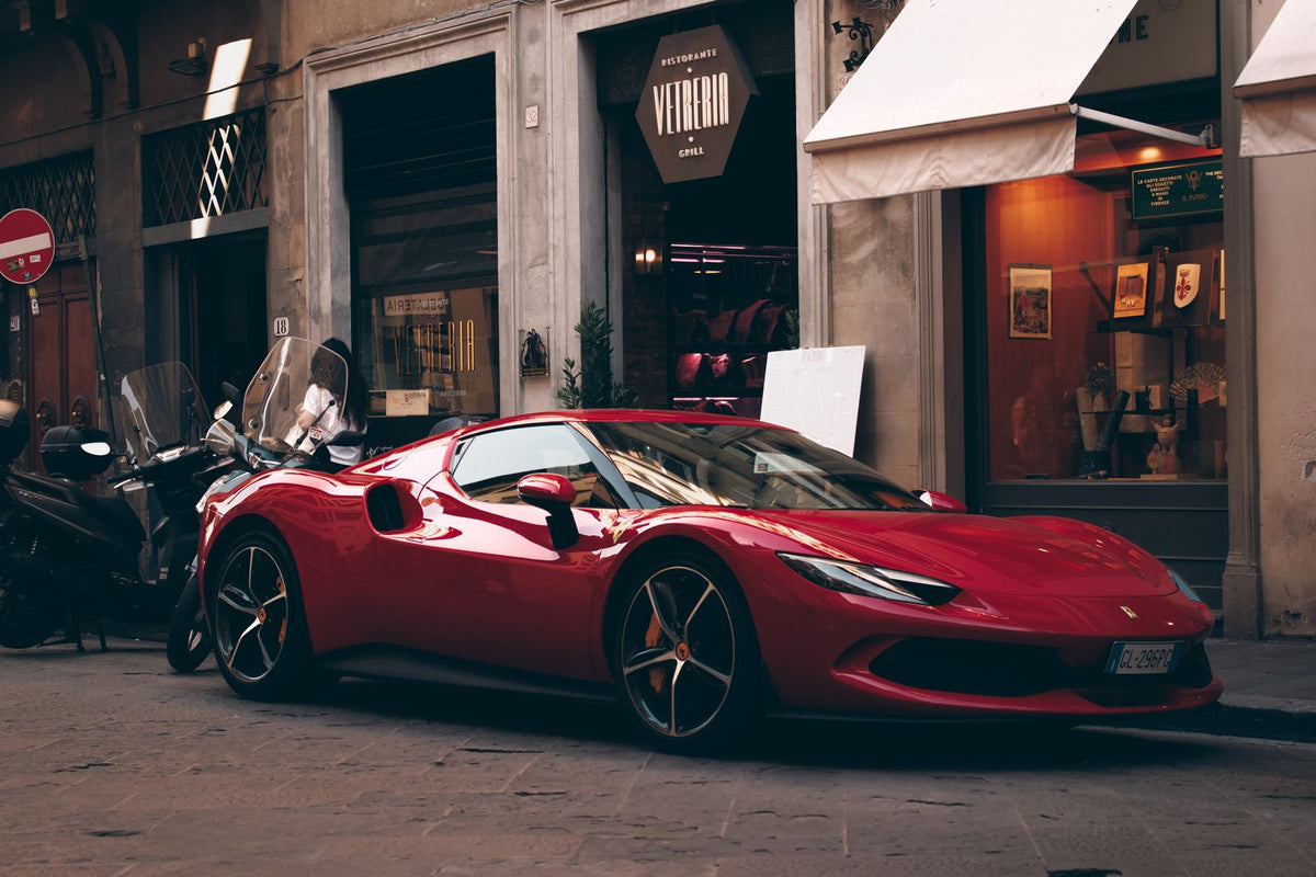 Red Ferrari 296 GTS parked on a street in Florence