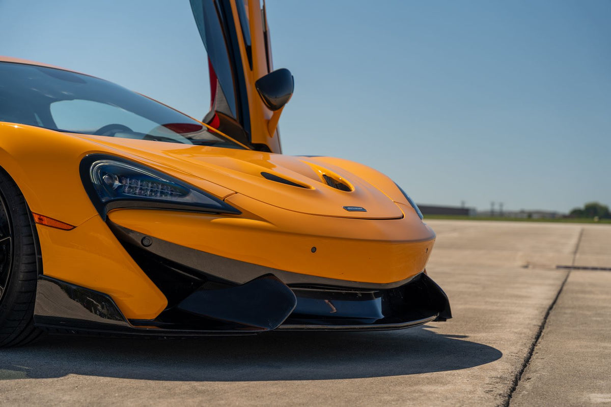 Orange McLaren sports car with doors open