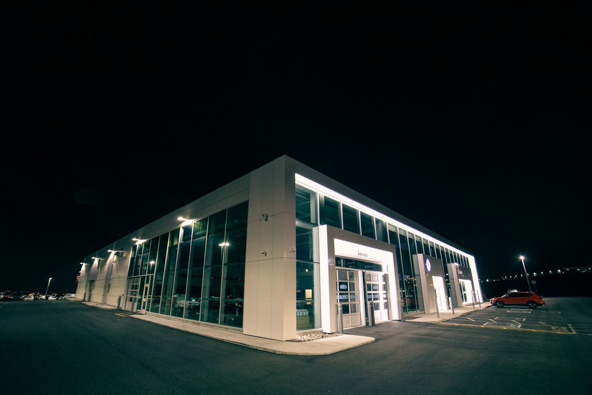 Car dealership service building lit at night